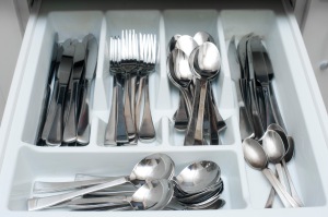 a kitchen cutlery drawer full of knives, forks and spoons